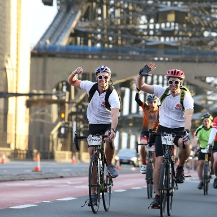 group of people cycling and waving at camera