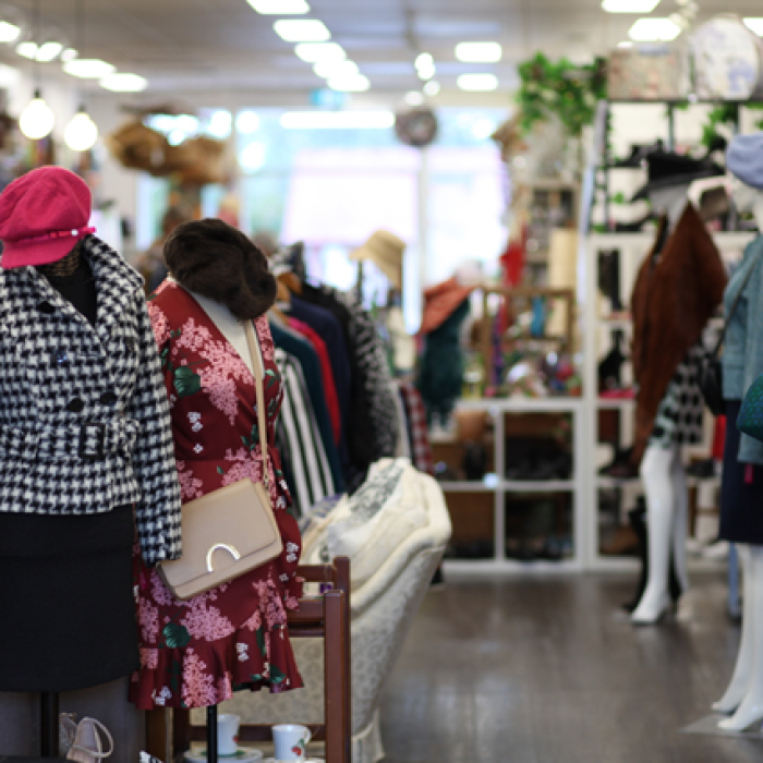 Mannequins and clothing racks inside a second-hand clothing store.