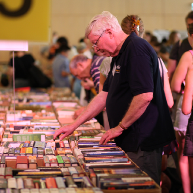 people looking through books at a fair